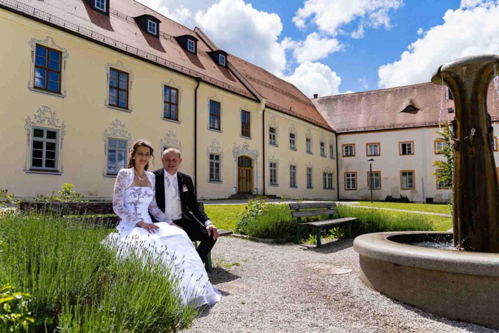 Christine und Andreas sitzen auf der Bank im Kloster Scheyern beim Brautpaarshooting