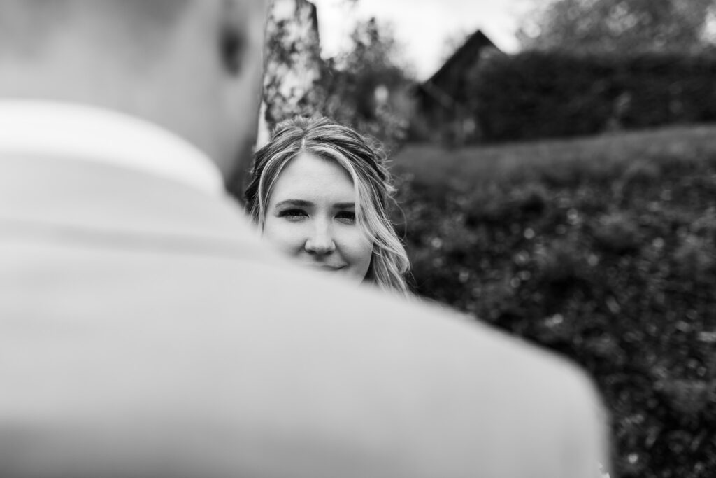 Jana und Cornelius beim Brautpaarshooting mit den Hochzeitsfotografen Mainburg. Jana blickt über die Schulter von Cornelius.