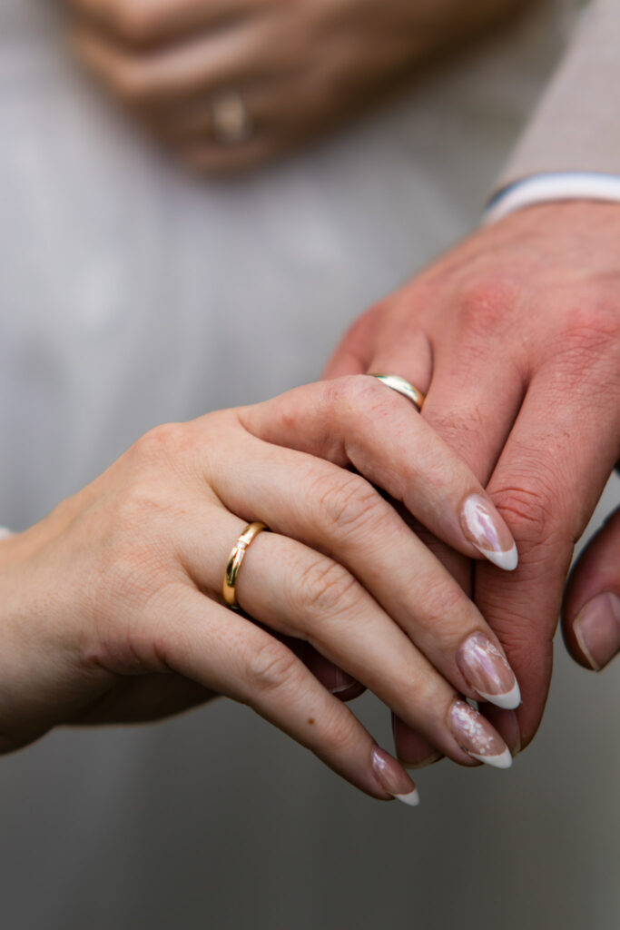 Jana und Cornelius beim Brautpaarshooting mit den Hochzeitsfotografen Mainburg. Die Ringe an beiden Händen in der Nahaufnahme.