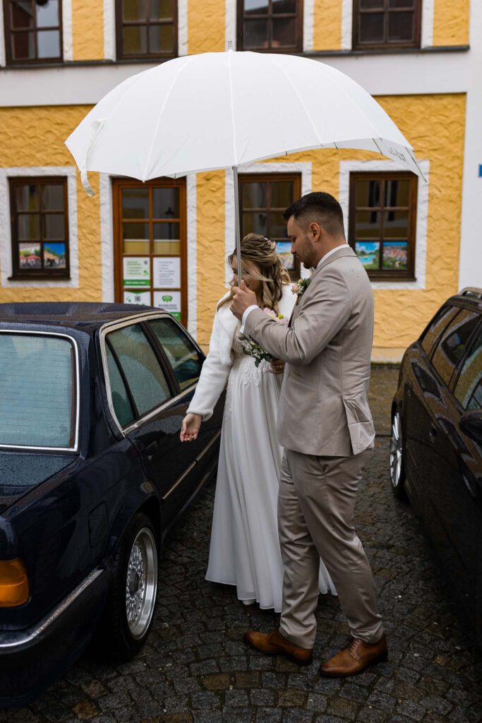 Jana und Cornelius steigen beim Standesamt in Mainburg aus ihrem Hochzeitsauto aus.