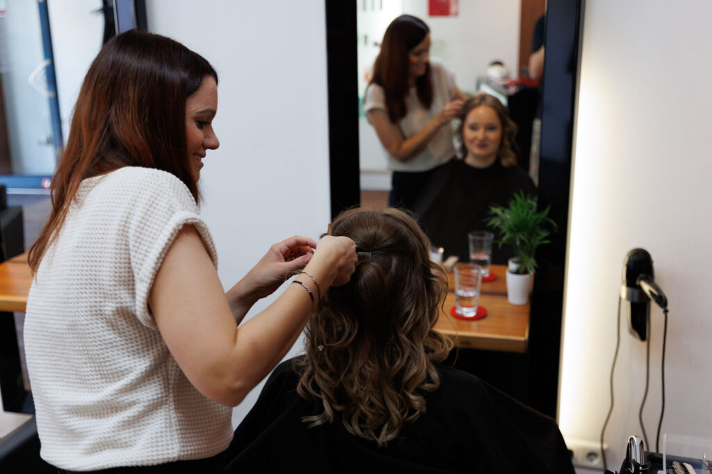 Jessica beim Getting-Ready bei Friseurin Haarkunst Claudia SIgl in Rohrbach beim stecken der Brautfrisur.