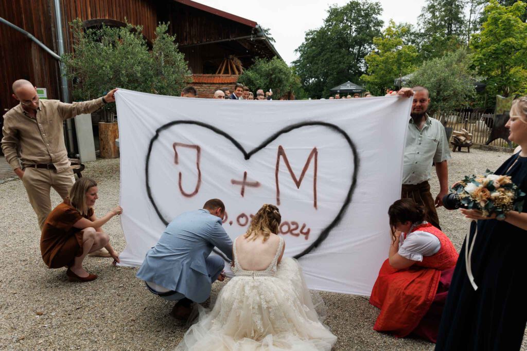 Jessica und Manuel beim Herzausschneiden begleitet von den Hochzeitsfotografen Pfaffenhofen.