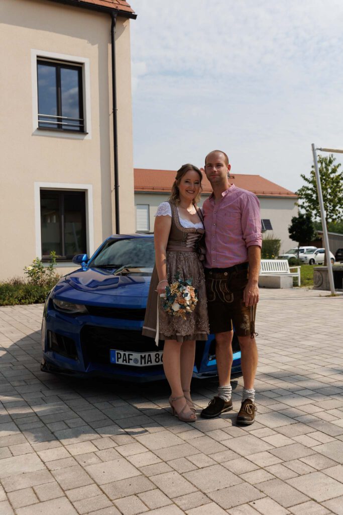 Jessica und Manuel vor dem Brautauto vor Ihrer standesamtlichen Trauung im Standesamt Hettenshausen.