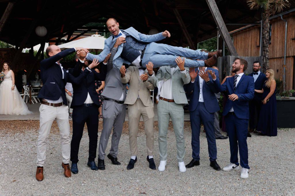 Manuel wird im Stockerhof Pfaffenhofen von seinen Jungs bei den Gruppenfotos hochgeworfen.