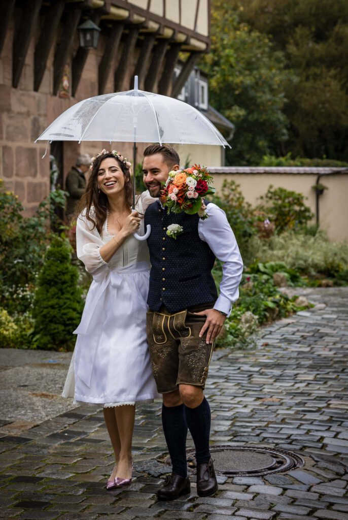 Or und Andreas unterm Regenschirm beim Standesamt Nürnberg im Pellerschloss in Fischbach.