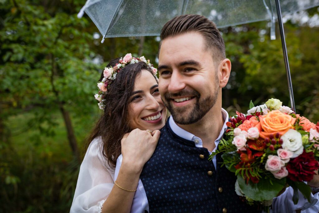 Or und Andi bei Brautpaarshooting nach Ihrer Hochzeit in Nürnberg. Or schaut Andi verliebt unter dem Regenschirm an.