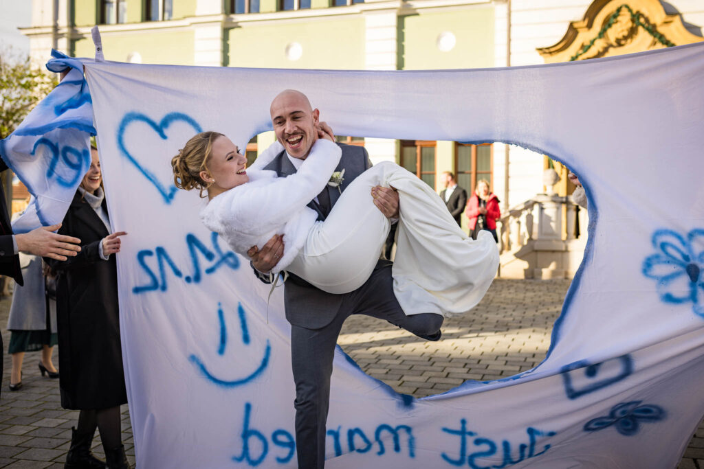 Der lustige Brauch „Herzausschneiden“ vor dem Standesamt Wolnzach – festgehalten vom Hochzeitsfotograf Wolnzach mit Liebe zum Detail.
