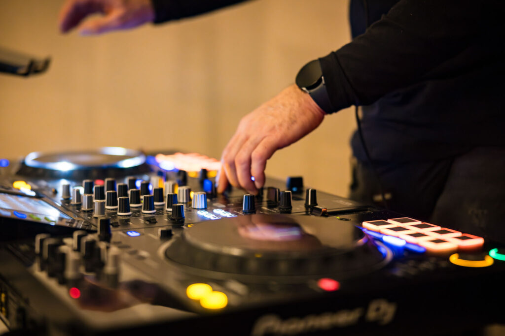 DJ bei der Arbeit am Mischpult – die Musik bringt Stimmung auf die Tanzfläche.