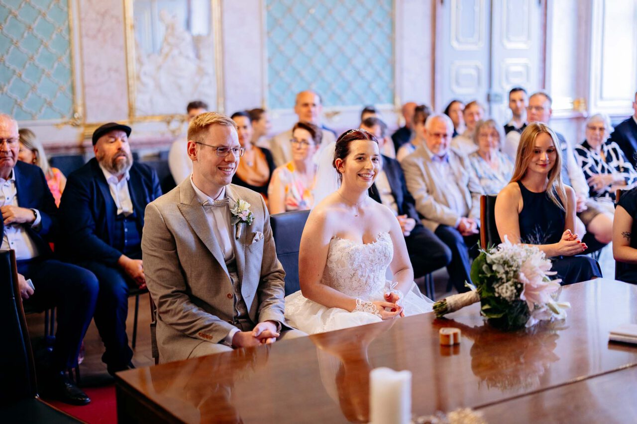 Brautpaar lacht im Standesamt Eichstätt bei der Rede der Standesbeamtin