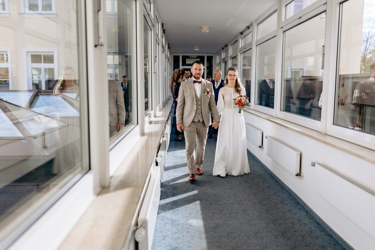Brautpaar auf den Weg zur standesamtlichen Trauung im Übergang im Standesamt Wolfratshausen