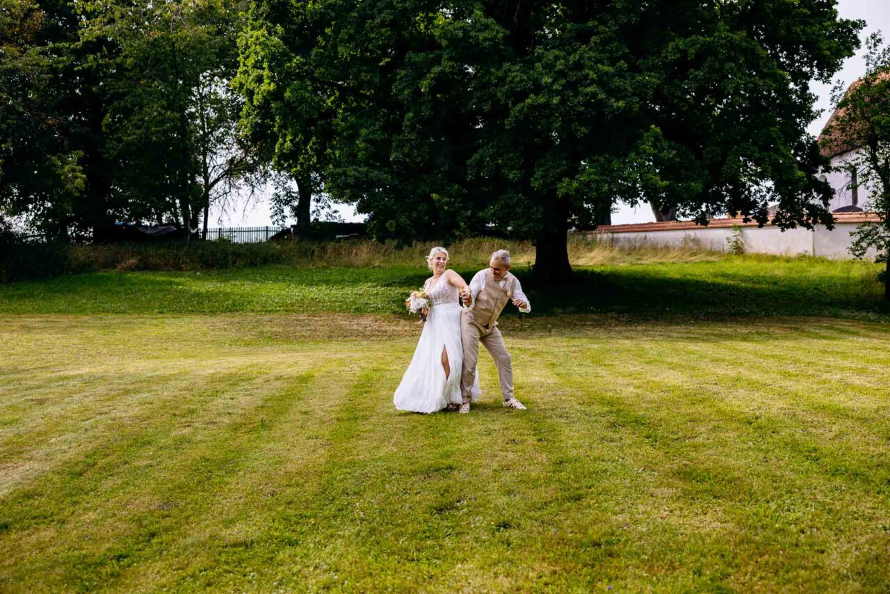 Brautpaar im großen Garten im Pfarrhof in Unterbrunn beim Brautpaarshooting mit viel Spaß