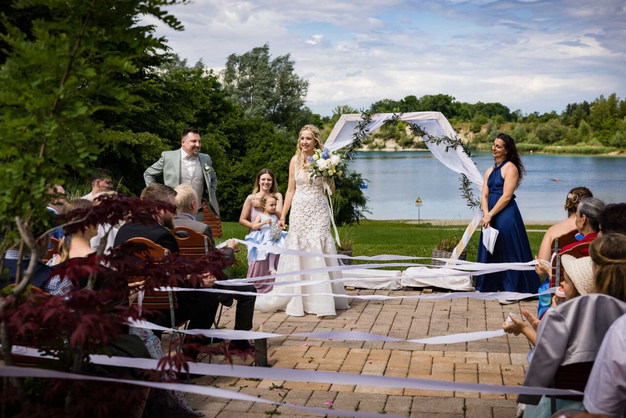 Das Brautpaar nach dem Einzug mit dem Pucher Meer im Hintergrund bei ihrer freien Trauung