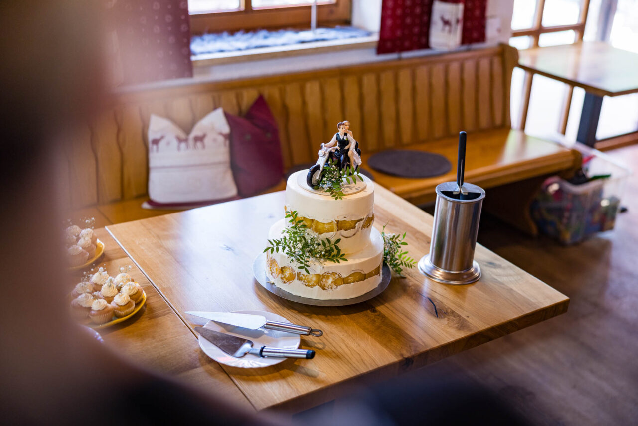 Hochzeitstorte mit einem dekorierten Brautpaar auf einem Motorrad auf der Torte die geschmückt ist mit Zitronen