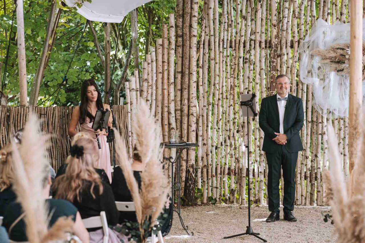 Trauredner Roland Müller wartet mit den Hochzeitsgästen auf den Einzug der Braut beim Landgasthof Rockermeier