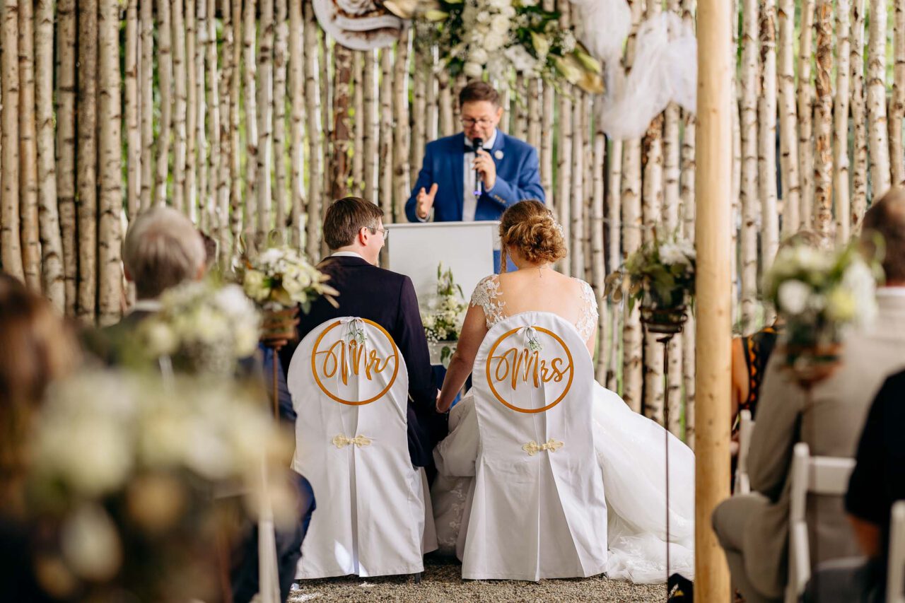 Das Brautpaar im Fokus sitzt vor ihrem Trauredner Harald Meyer beim Rockermeier in Unterpindhart