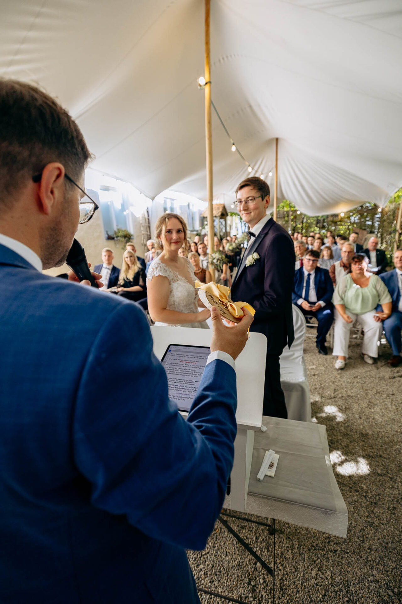 Trauredner Harald Meyer hat die Ringe vom Brautpaar das vor ihm steht in der Hand.