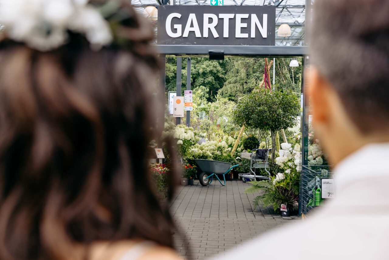Das Brautpaar Blickt auf ein Schild mit dem Aufdruck Garten