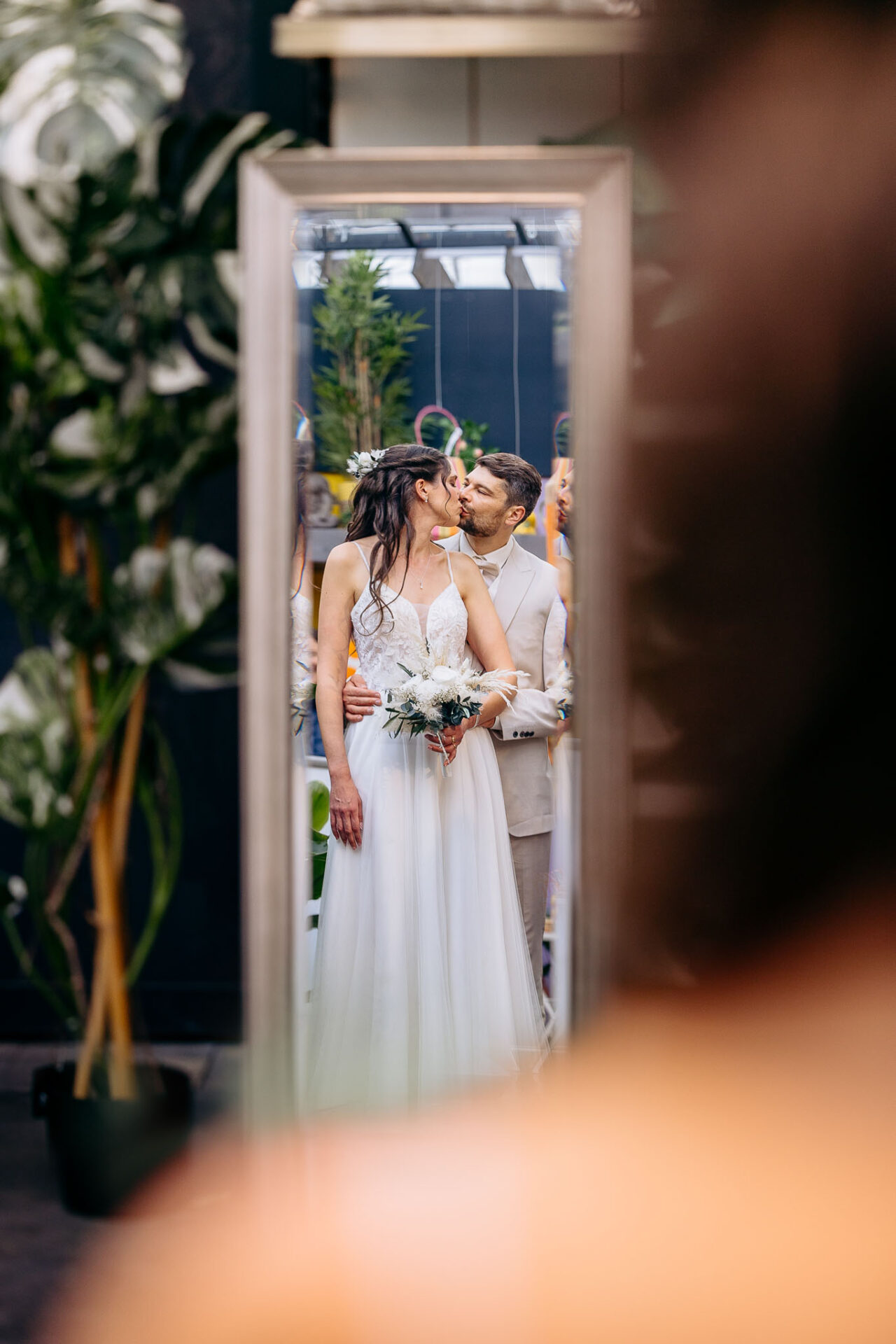 Das Brautpaar spiegelt sich im Spiegel wieder während sie sich küssen