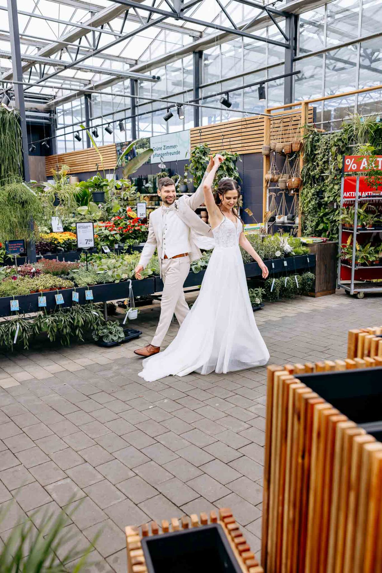 Brautpaar tanzt während es draußen regnet im Gartencenter Kiefl