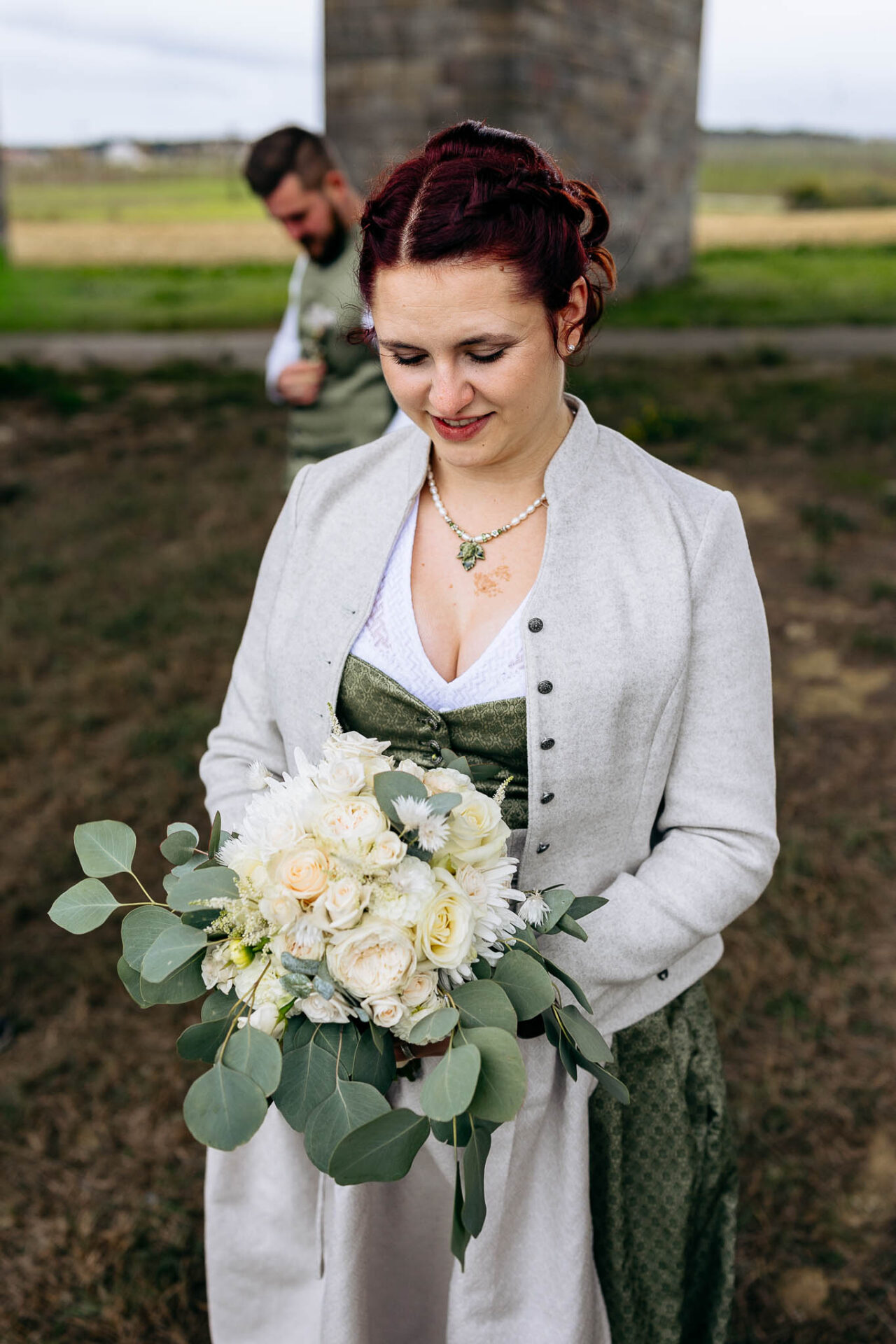 Braut Lena schaut auf Ihren Brautstrauß hinunter