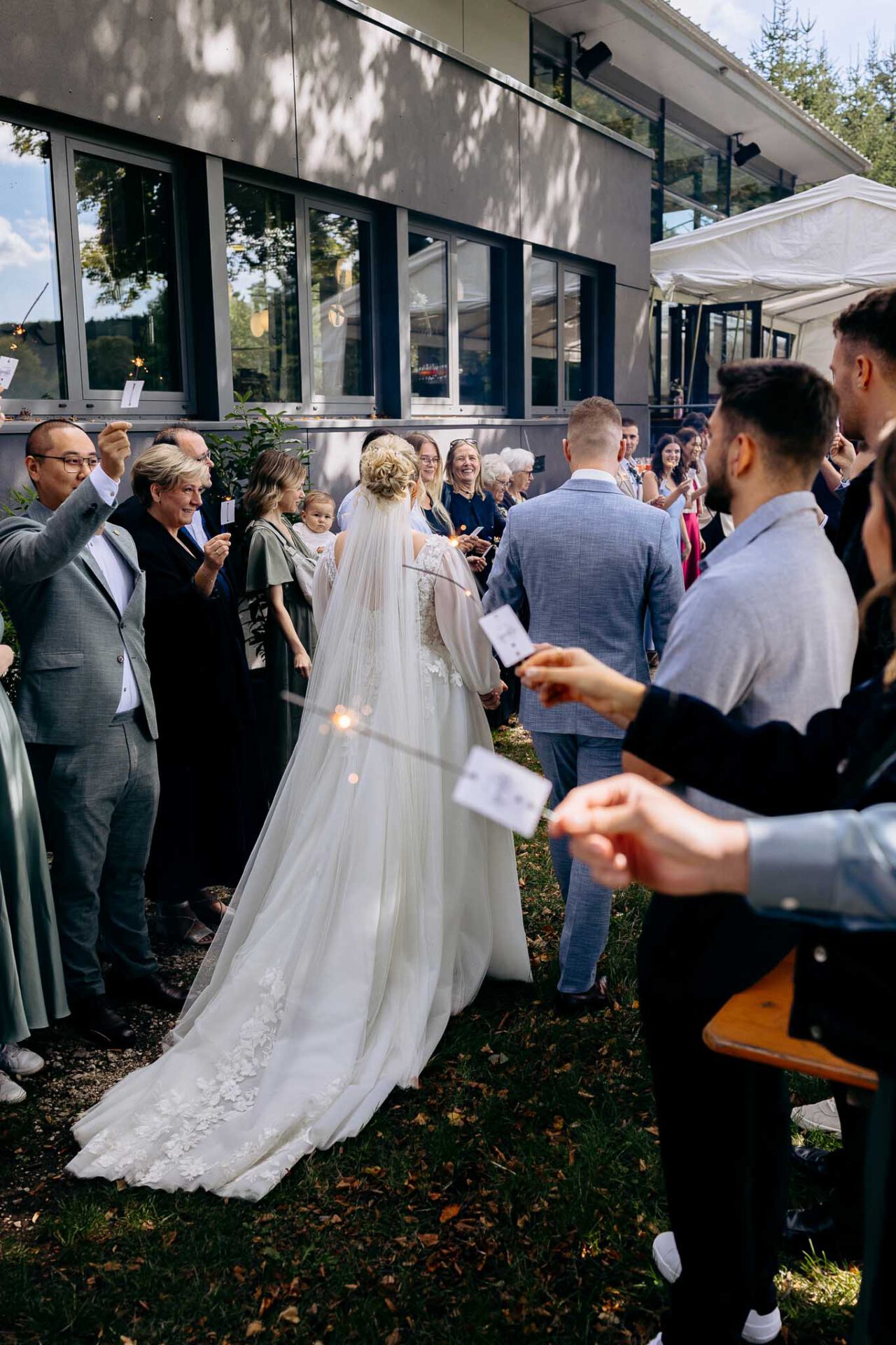 Das Brautpaar geht durch den Spalier aus Sternwerfern im Robos Waldblick