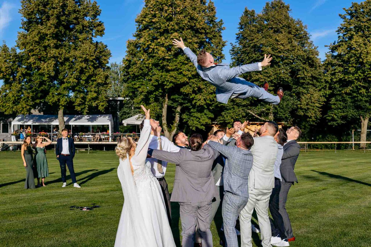 Der Bräutigam wird in die Luft geworfen von seinen Jungs