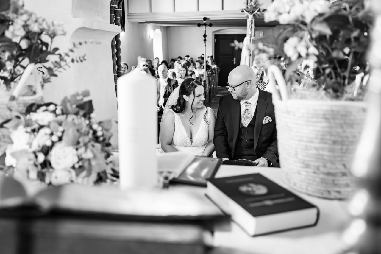 Das Brautpaar lächelt sich freudestrahlend in der Kirche in Holzingen an