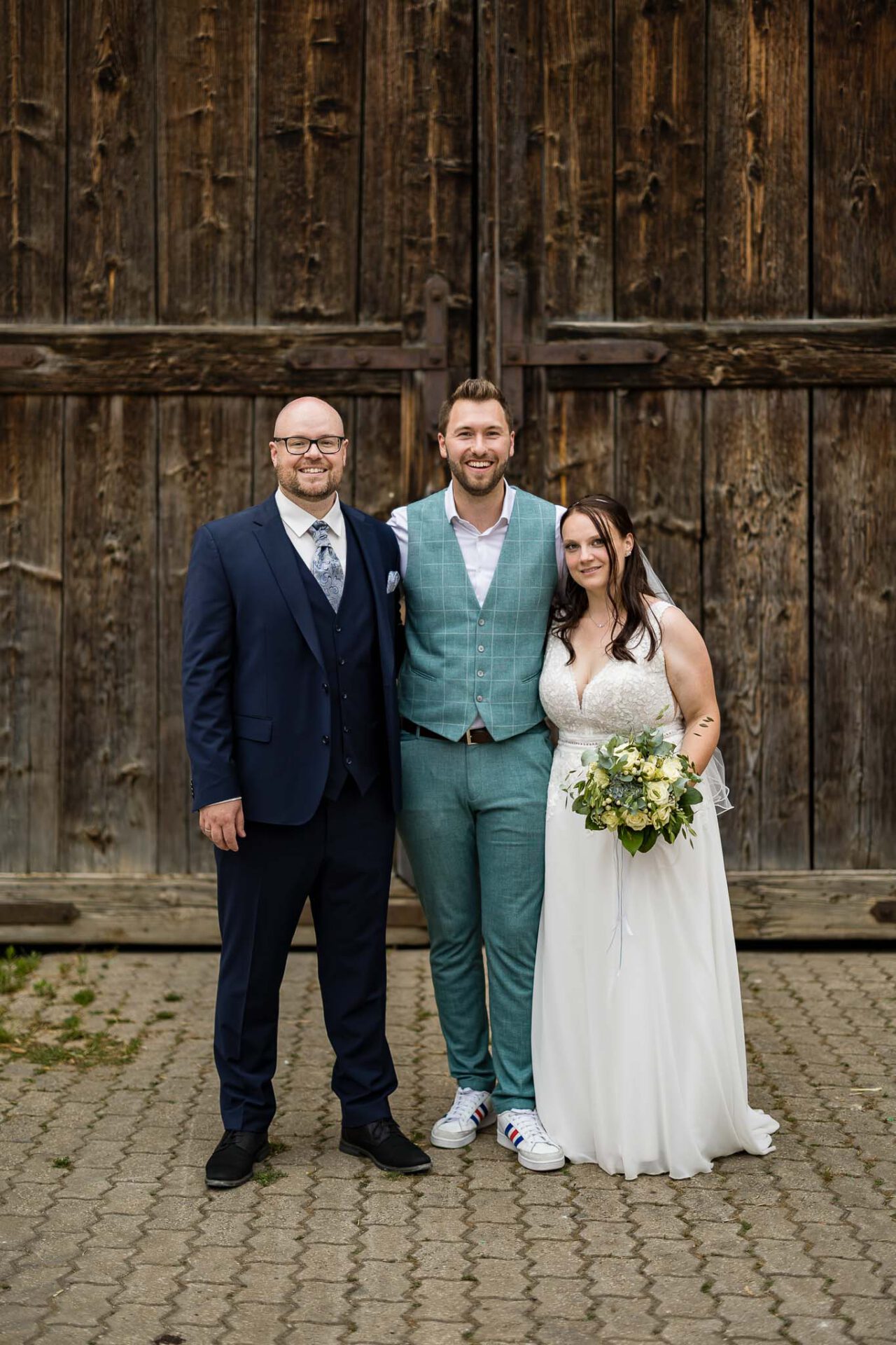 David Hoyer mit dem Brautpaar im Gruppenfoto im Schloss Fürst Carl Weißenburg