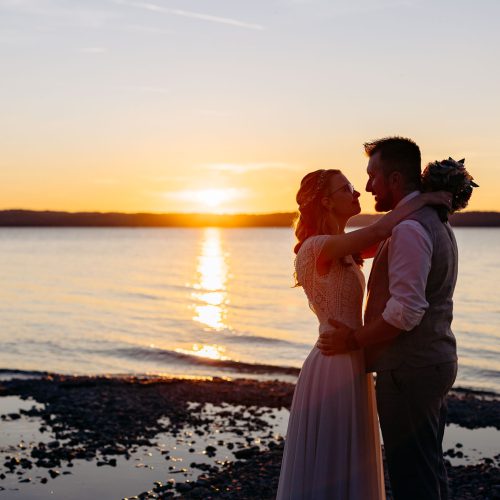 Brautpaar umarmt sich im Sonnenuntergang am Starnberger See